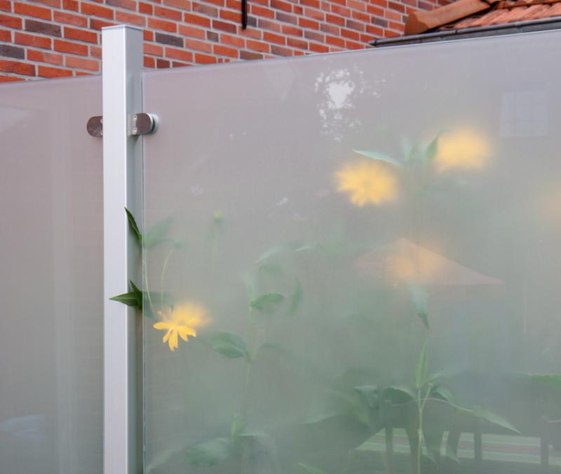 Groja Ambiente satiniert - Sichtschutz aus satiniertem Glas mit angedeuteten Pflanzen und gelben Blüten im Hintergrund