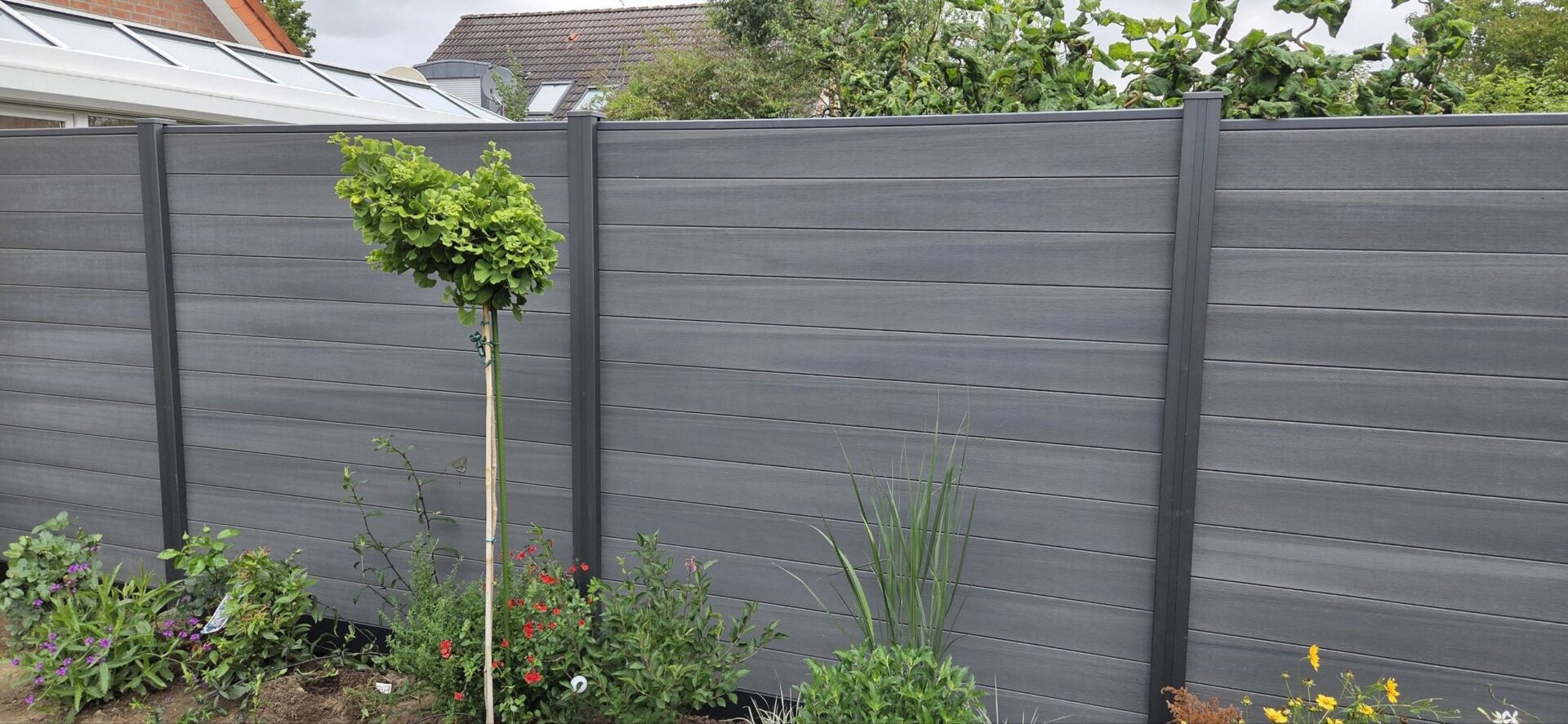 Schlichte, glatte Haustür mit horizontalen Linien und silbernem Türgriff in dunklem Grauton
