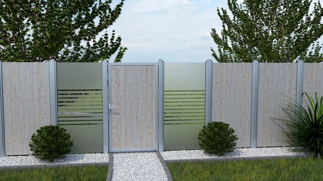 Groja Premo - Gartenzaun mit Sichtschutz aus Holz und Glas mit Tür, davor ein Kiesweg und ein Busch