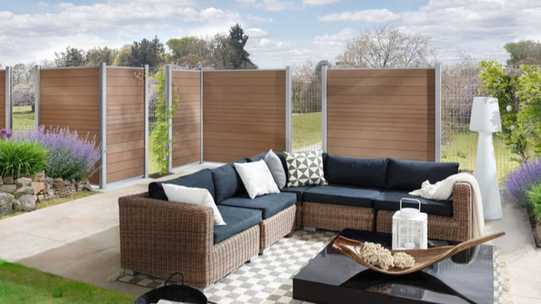 Traumgarten System WPC Classic Sichtschutzzaun braun auf Terrasse mit Loungemöbeln