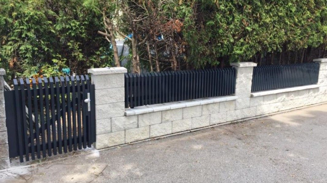 Guardi Palermo Gartenzaun anthrazit mit Schrägkappen, senkrechte Latten auf Steinmauer