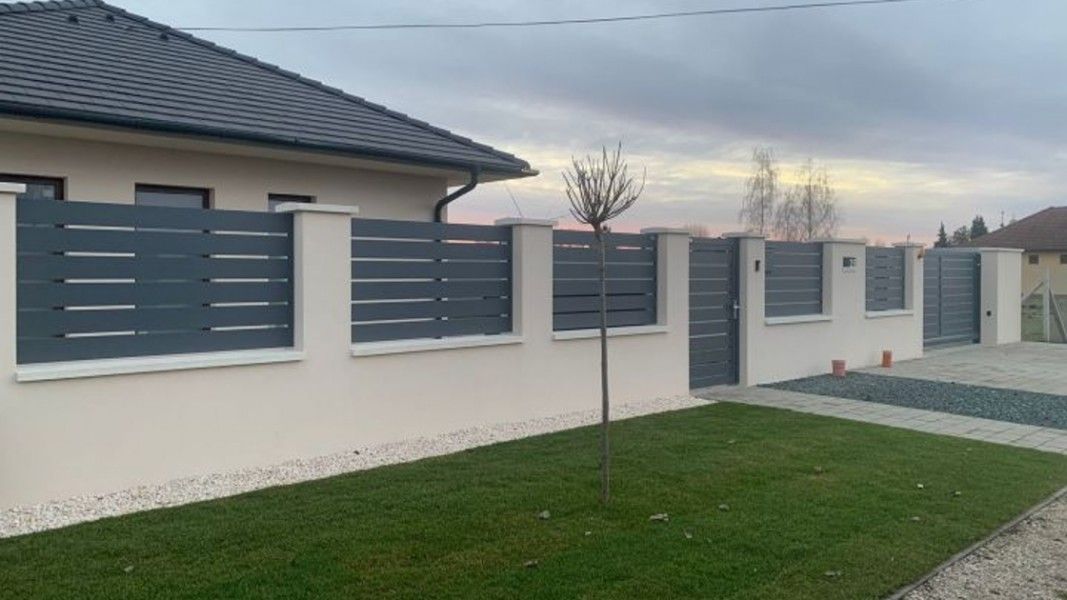 Guardi Triest Aluzaun anthrazit mit breiten Latten, Einfamilienhaus Abenddämmerung